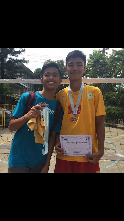 Throwback photo of two friends wearing medals at an outdoor court